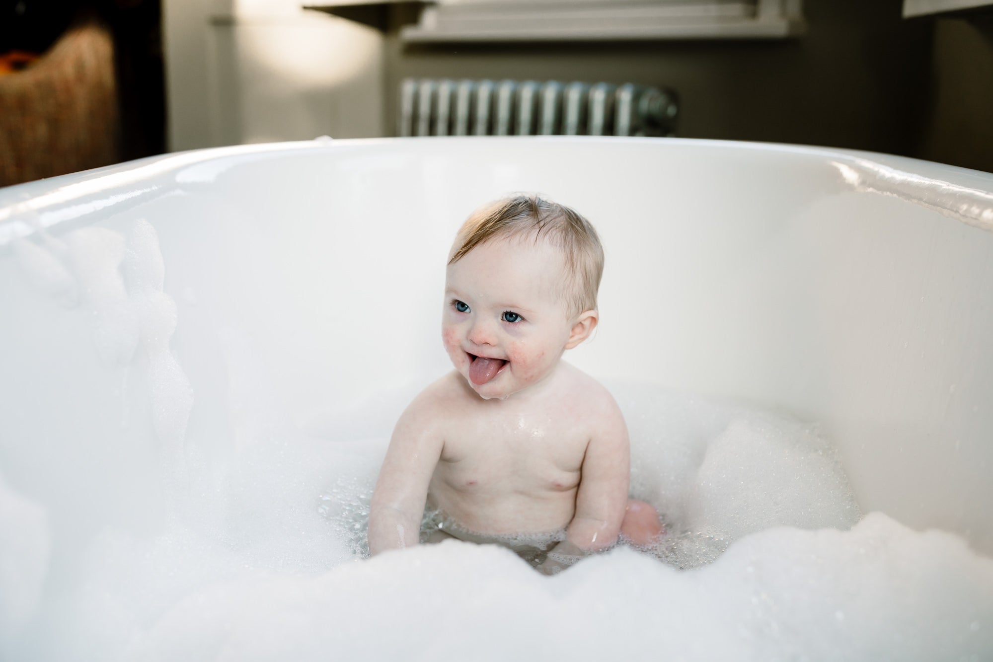 Happy baby enjoying a sulphate-free bubble bath, surrounded by bubbles
