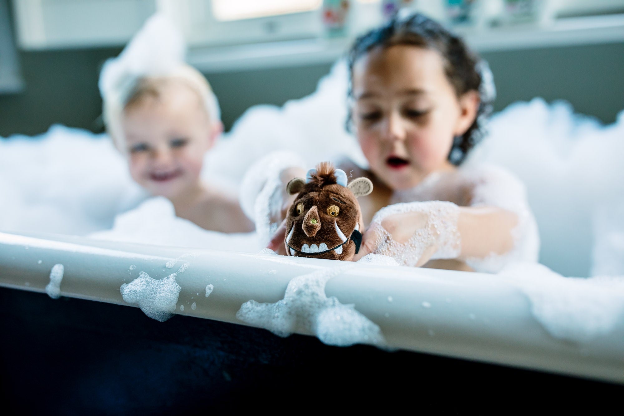 two children playing in the bath with bubbles and the gruffalo